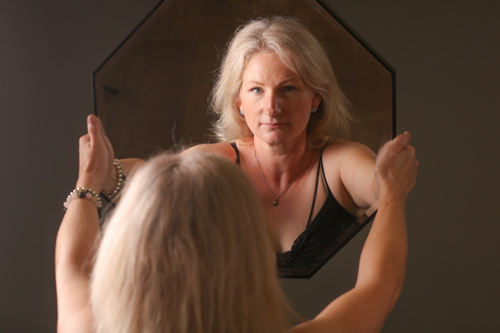 Woman checking her hair in a mirror